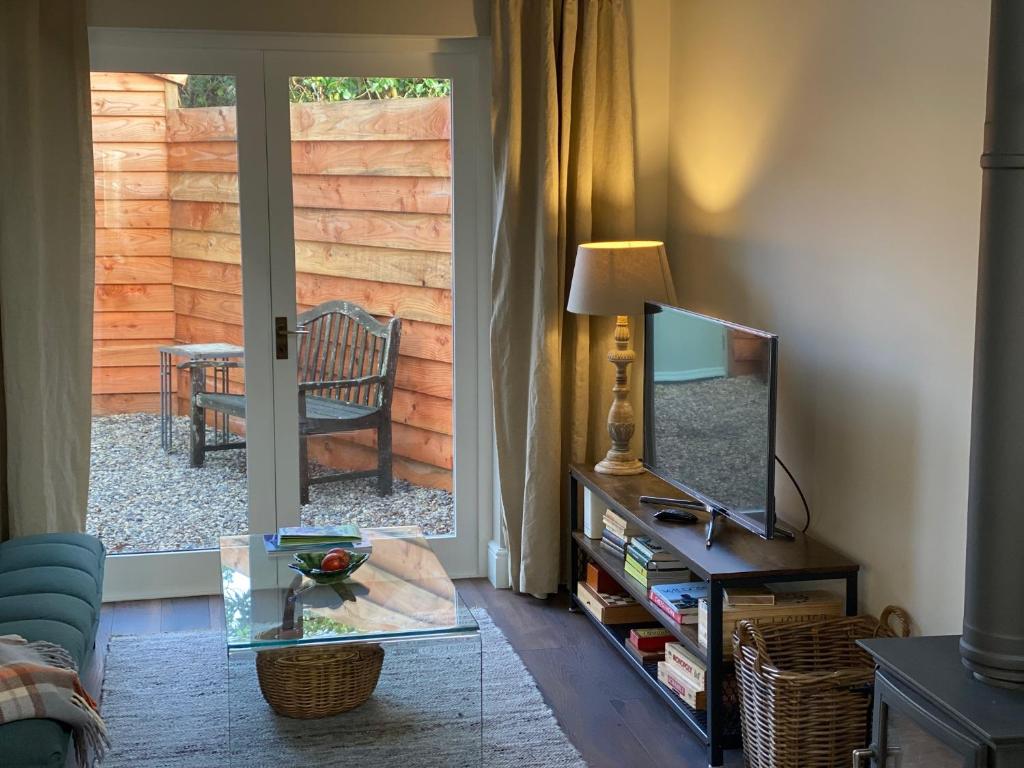 a living room with a glass table and a mirror at Pear Tree Cabin in Beaulieu