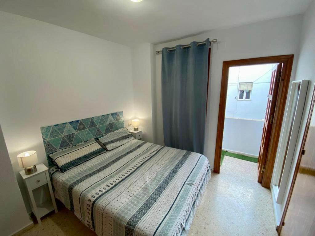 1 dormitorio con 1 cama y puerta a un balcón en Blue Corredera Vejer, en Vejer de la Frontera