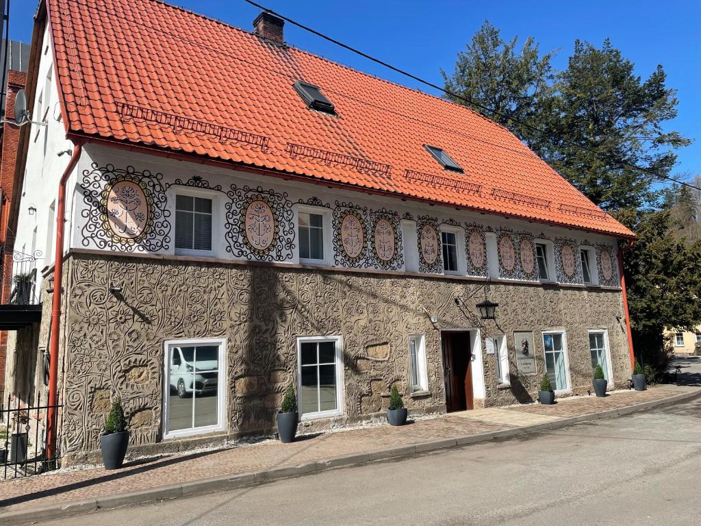 un vieux bâtiment avec un toit orange dans une rue dans l'établissement Apartament Pola, à Sokołowsko
