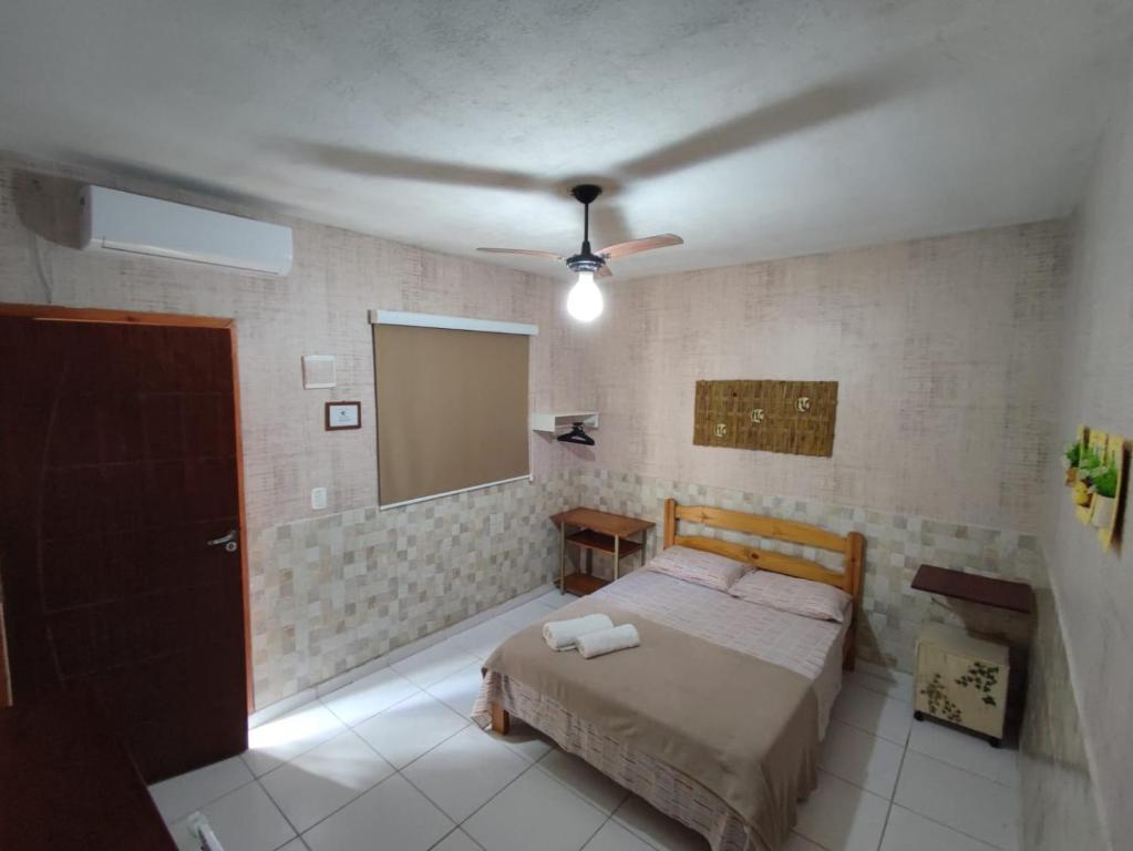 a bedroom with a bed and a mirror at Suítes Veleiro in Ubatuba