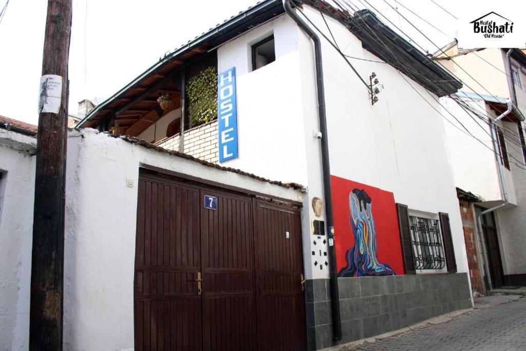 un bâtiment avec une porte marron sur son côté dans l'établissement Hostel Bushati, à Prizren