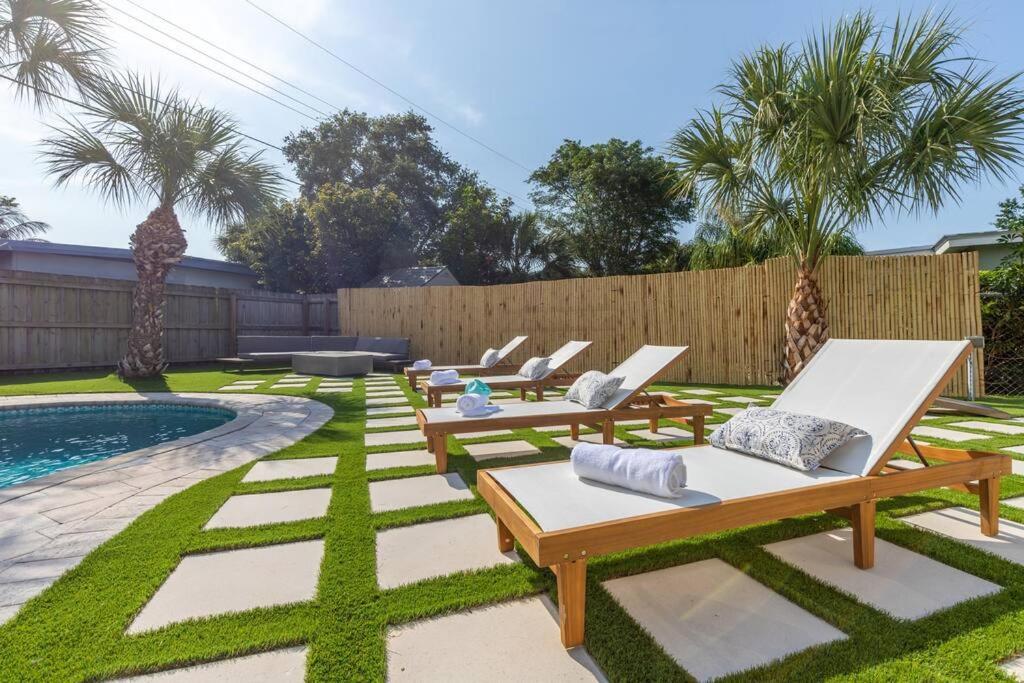 a backyard with lounge chairs and a swimming pool at *NEW* The Palm Garden - Bright, Tropical Retreat! in Palm Beach Gardens