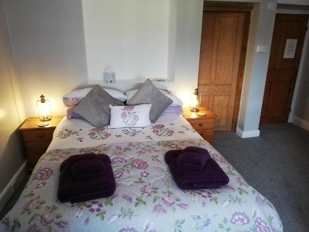 a bedroom with a bed with two towels on it at Rainors farm B&B in Gosforth
