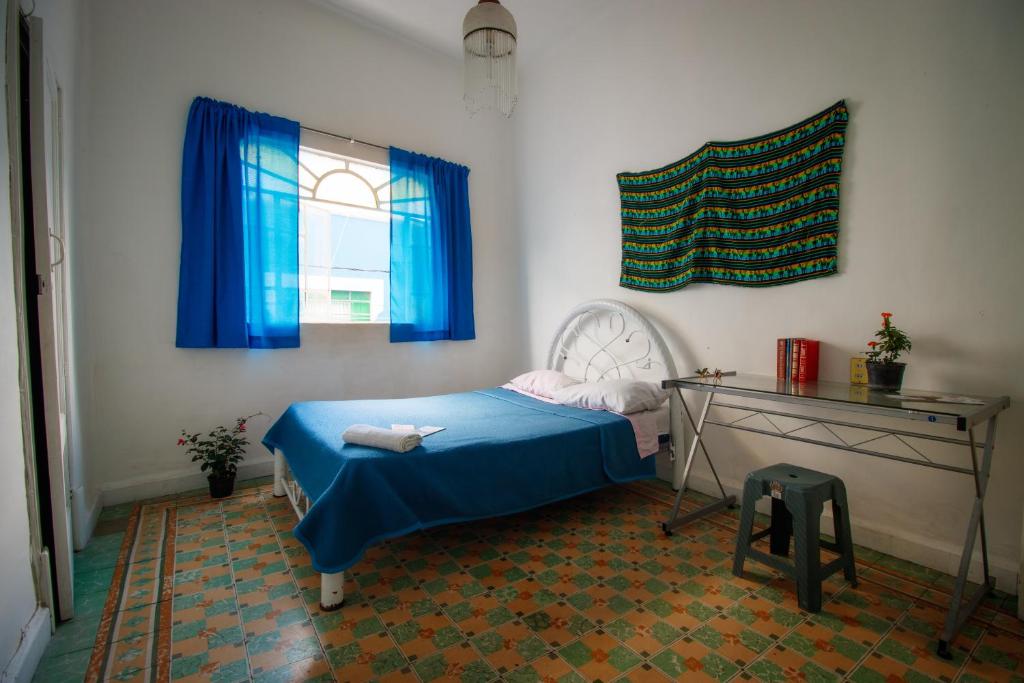 a bedroom with a blue bed and a window at Hostal Azul Puebla Barrio El Alto in Puebla