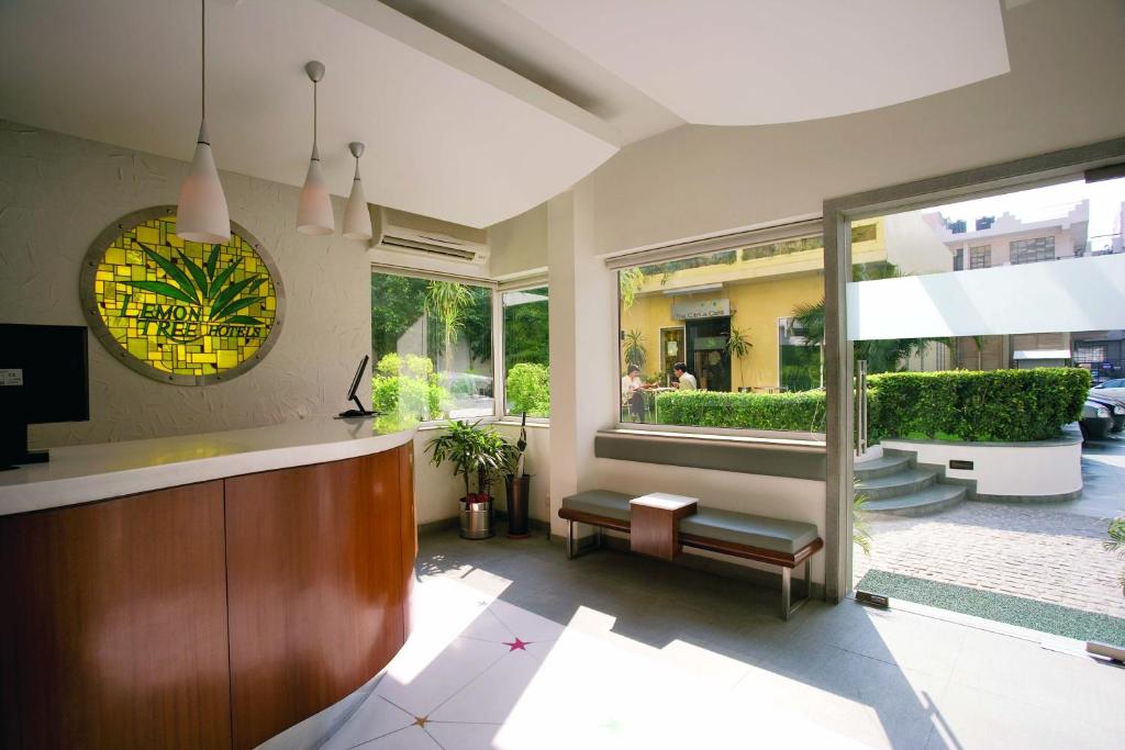 a living room with a counter and a large window at Lemon Tree Hotel, Udyog Vihar, Gurugram in Gurgaon