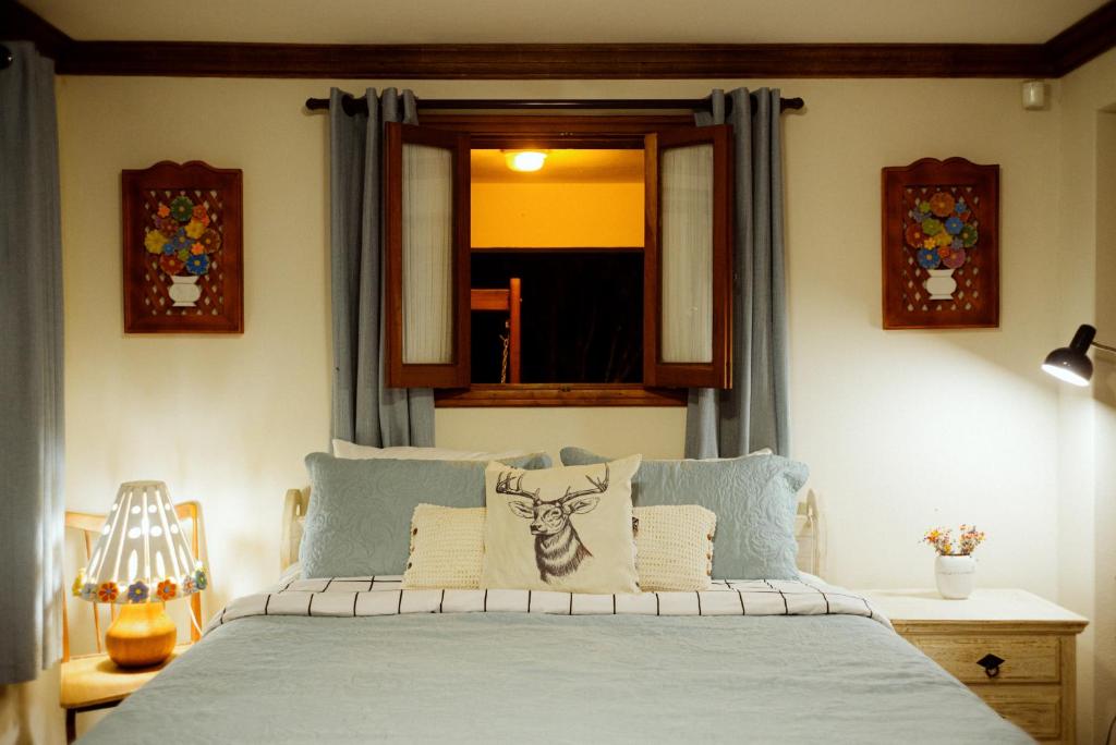 een slaapkamer met een bed en een raam bij Cabana Mimosa in Monte Verde