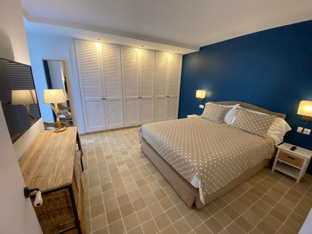 a bedroom with a bed and a blue wall at Hotel Playa Sol in Cadaqués