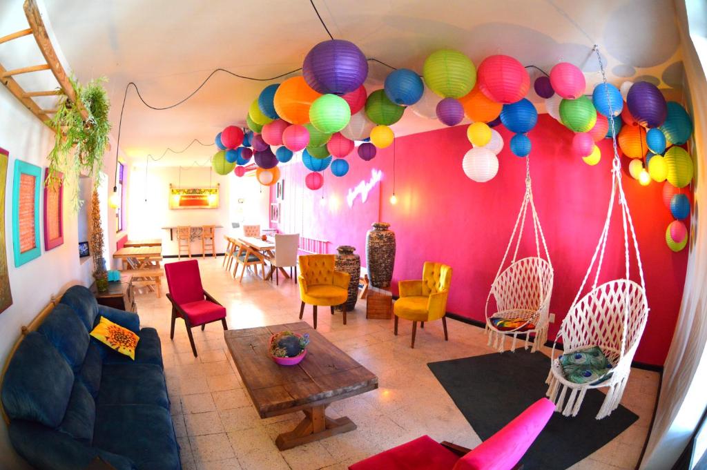 una sala de estar con globos coloridos colgando de una pared en Vivir Bonito Hostal en Morelia