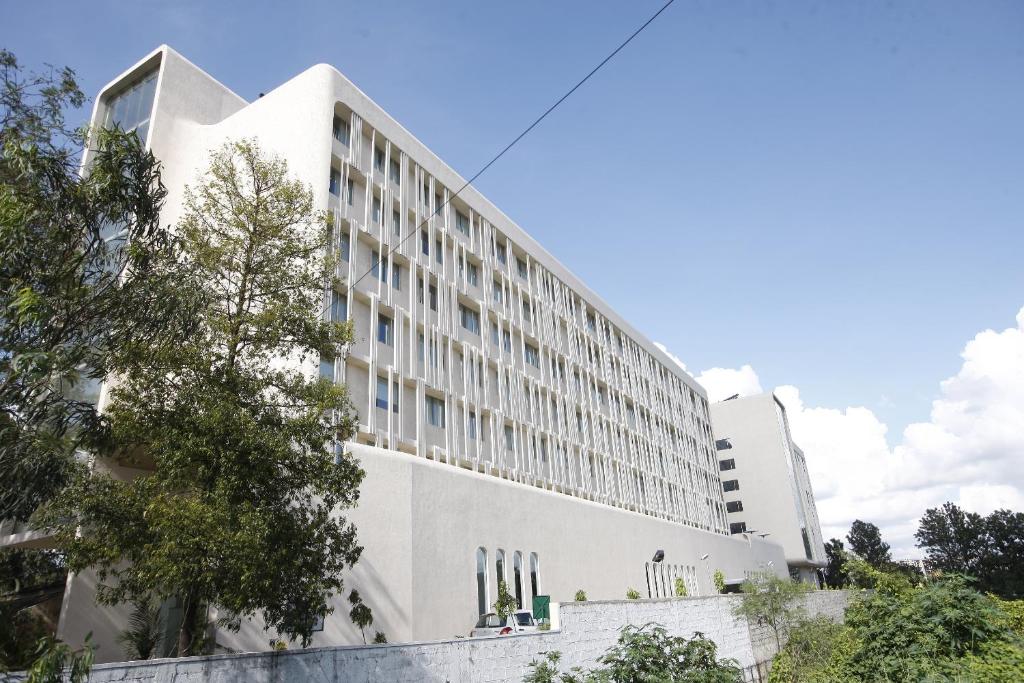 a white building with trees in front of it at Keys Select by Lemon Tree Hotels, Whitefield, Bengaluru in Bangalore