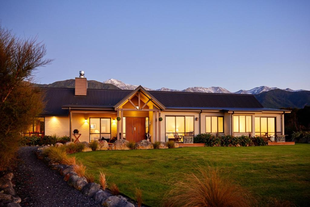 a home with mountains in the background at Manakau Lodge in Kaikoura
