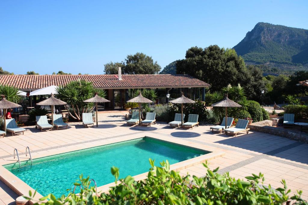 a pool at a resort with chairs and umbrellas at Ca's Garriguer in Valldemossa