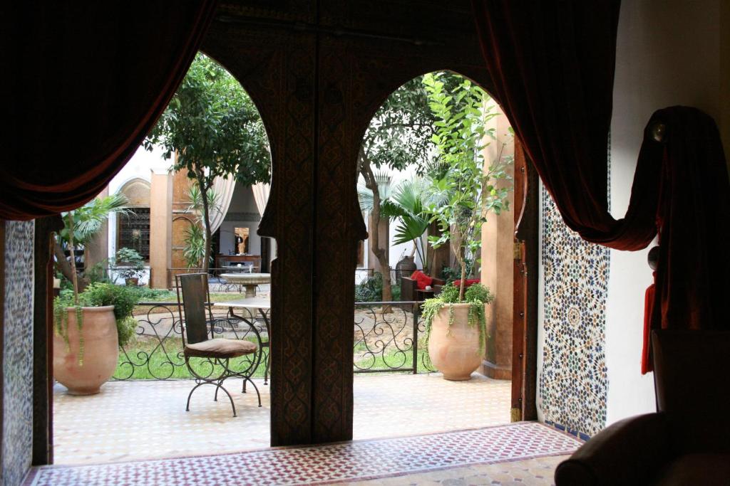 een open deur naar een patio met een stoel bij Riad Laaroussa in Fès
