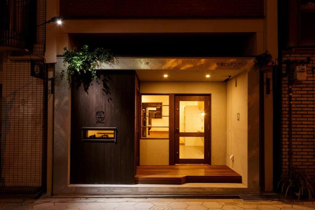 a front door of a building at night at Guest House Sora 3rooms in Osaka