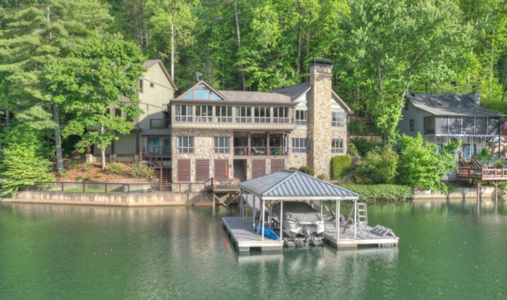 ein großes Haus am Wasser mit einem Dock in der Unterkunft Country Roads in Morganton