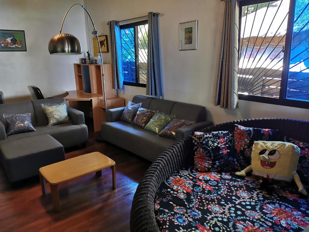 sala de estar con sofá y mesa en 3-Bedroom Beach House at Glamping Dome Beach Resort, en Dauin