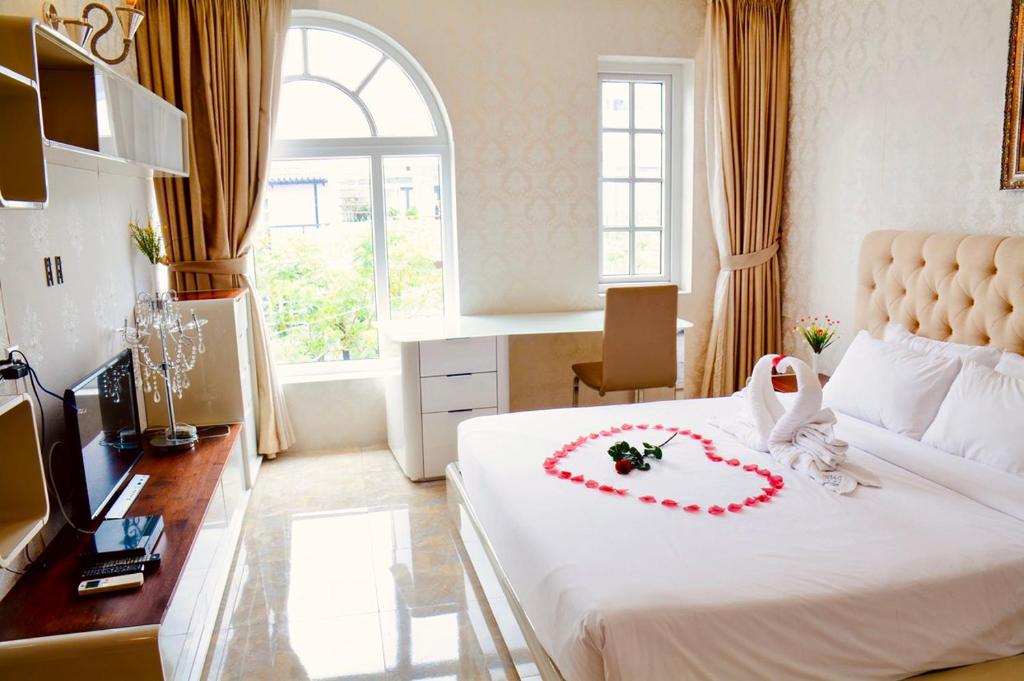 - une chambre avec un lit blanc et un bouquet de cadeaux de mariage dans l'établissement Golden Hotel & Apartment, à Hô-Chi-Minh-Ville