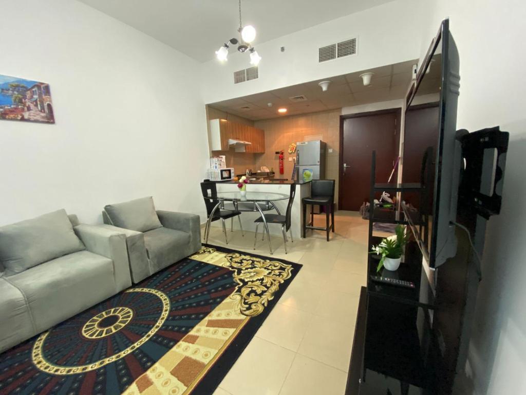 a living room with a couch and a table at Lovely 1-bedroom Apartment with free Parking on premises in Ajman 