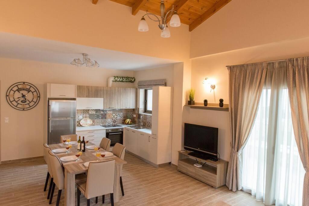 salon ze stołem jadalnym i kuchnią w obiekcie Rose Villa with Private Pool w mieście Roúpai