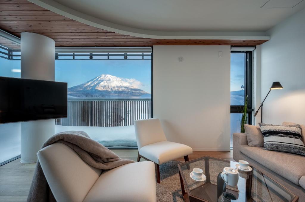 uma sala de estar com vista para uma montanha coberta de neve em Yotei Dream One by H2 Life em Niseko