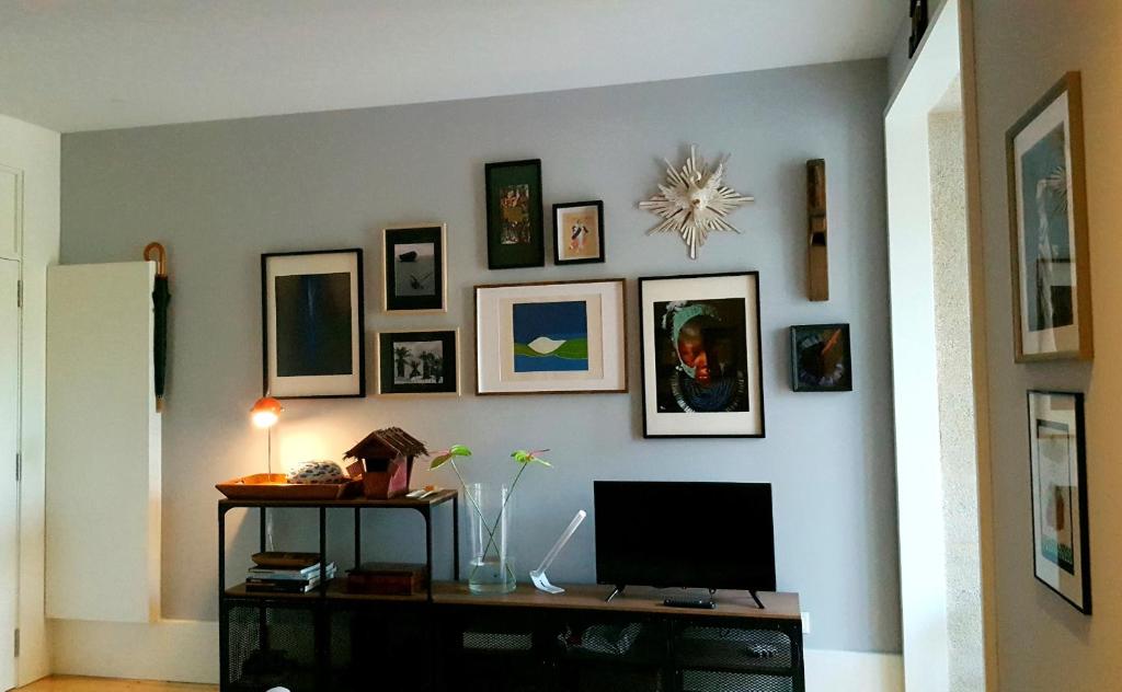 una camera con TV e parete con immagini di Boavista Charming Apartment with Garden by Great&Cosy a Porto