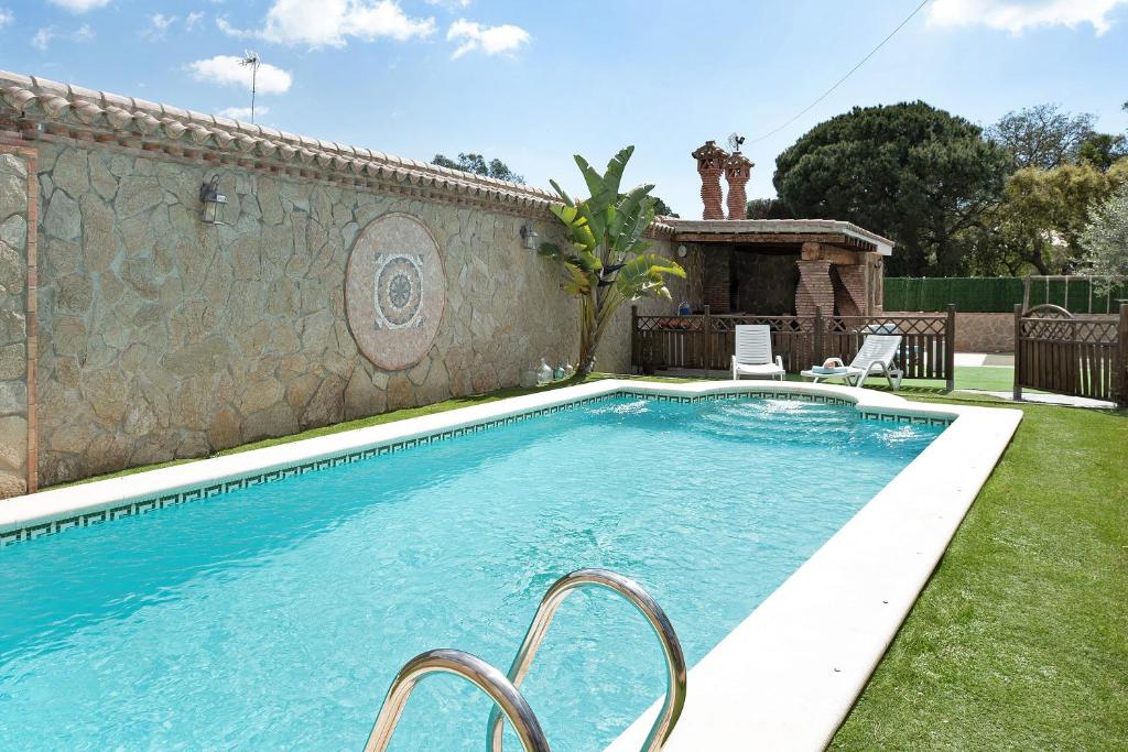 una piscina en un patio junto a una pared en Villa Africa en La Muela