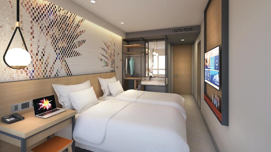 Go Hotels Plus Naga في نجا: غرفة نوم مع سرير أبيض كبير ومكتب