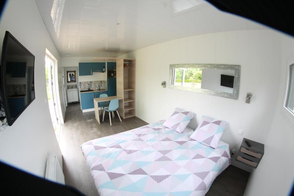 ein kleines Schlafzimmer mit einem Bett und einer Küche in der Unterkunft Gîte et chambre d'hôtes en Champagne in Courtisols