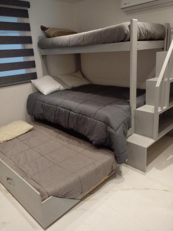 a bedroom with two bunk beds and a staircase at Marina del Sol Resort Condo directly on the Ocean 102 in Mazatlán