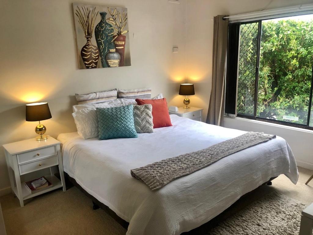 a bedroom with a large bed with pillows and a window at Hotel Style Monterey Guest Studio near Hospitals, Beach and Airport in Sydney