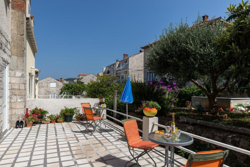 un patio con sillas, una mesa y una sombrilla en Guest House Bradas, en Dubrovnik