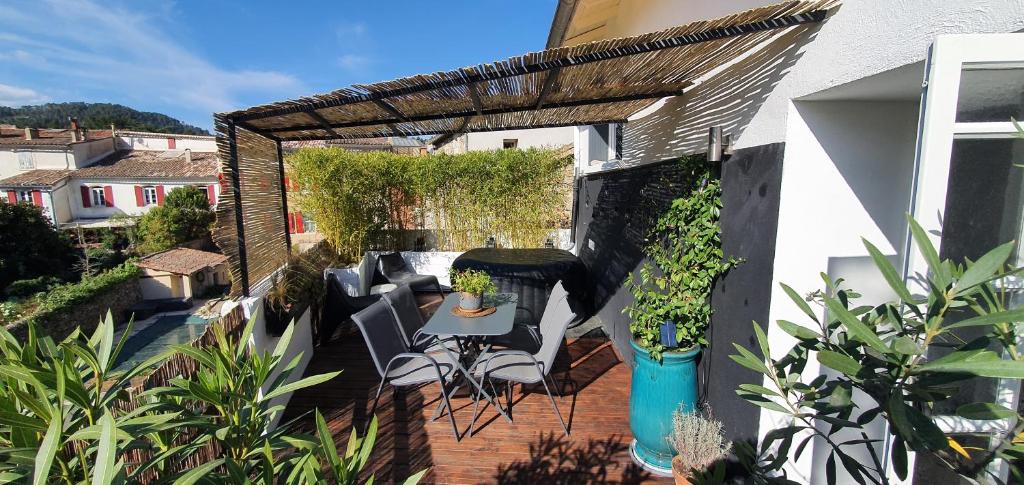 un patio extérieur avec une table, des chaises et des plantes dans l'établissement Duplex avec spa et terrasse en plein centre du village, à Saint-Jean-du-Gard