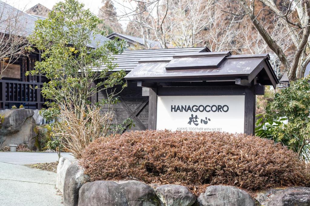 um sinal em frente a uma casa com um telhado em Hanare no Yado Hanagokoro em Minamioguni