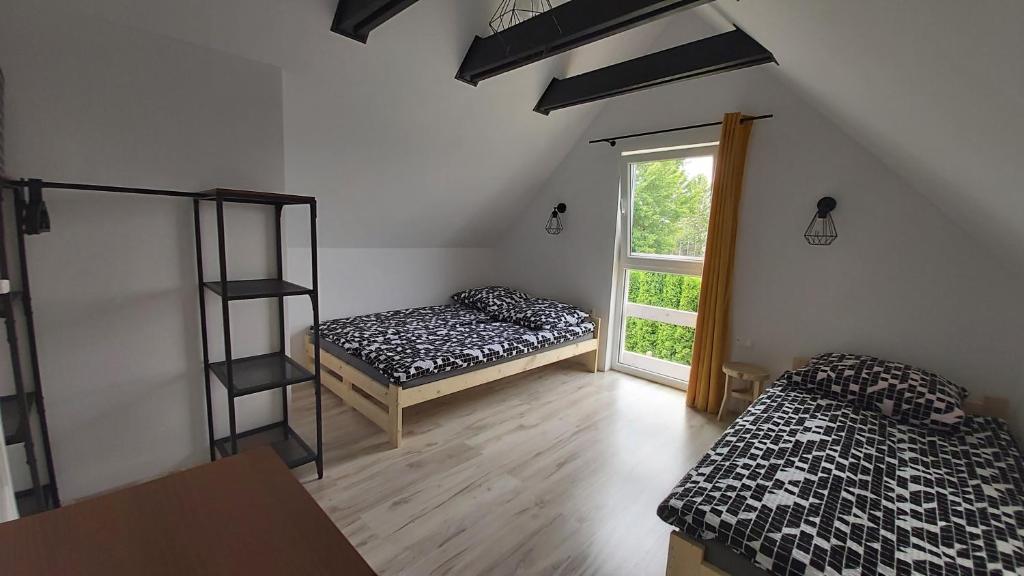 two beds in a room with a window at Poprzeczna 7 in Sarbinowo