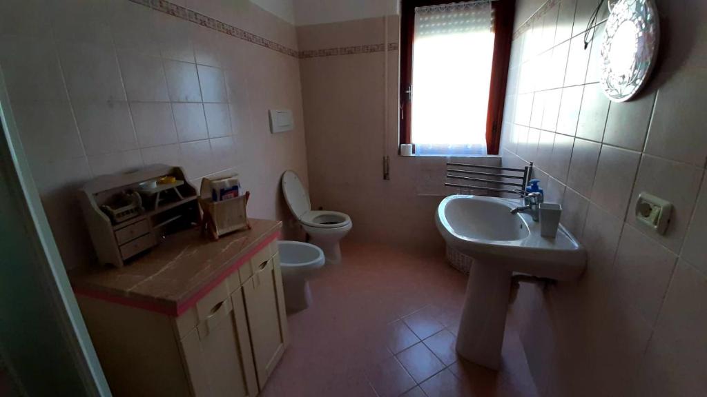 a bathroom with a sink and a toilet and a window at CASA VACANZE My Way in Cavo