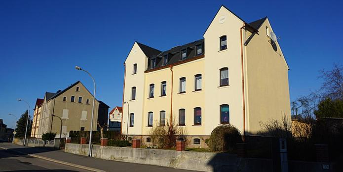 Burgstaedt的住宿－Ferienwohnung Burgstädt，街道边的白色大建筑