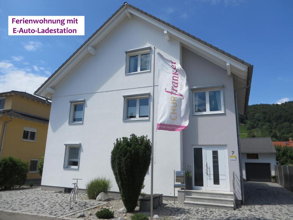 a white house with a flag in front of it at Ferienwohnung Familie Buchner in Großheubach
