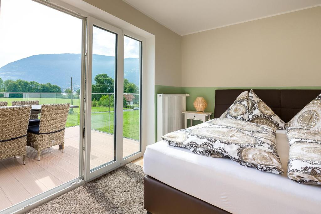 a bedroom with a bed and a balcony at Villa Müller Turmfalke in Ossiach