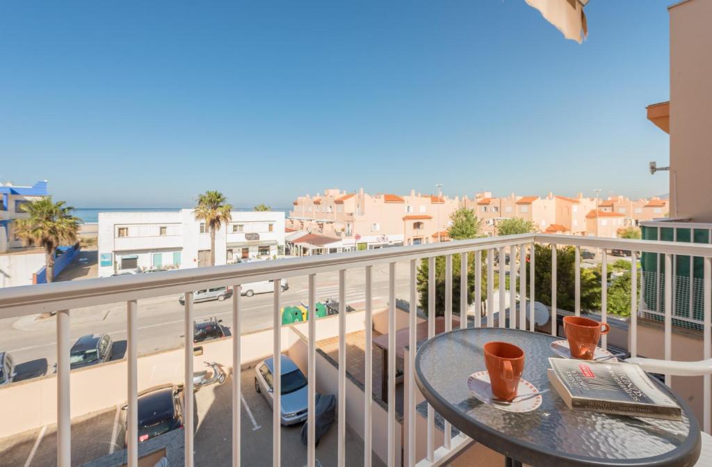 a balcony with a table and two cups of coffee at Apartamento Gaviotas Sureñas in Tarifa