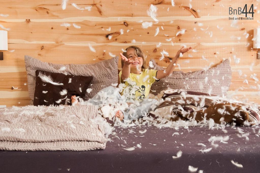 Ein kleines Mädchen auf einem Bett mit Popcorn in der Unterkunft BnB44 only rooms no breakfast in Bichlbach