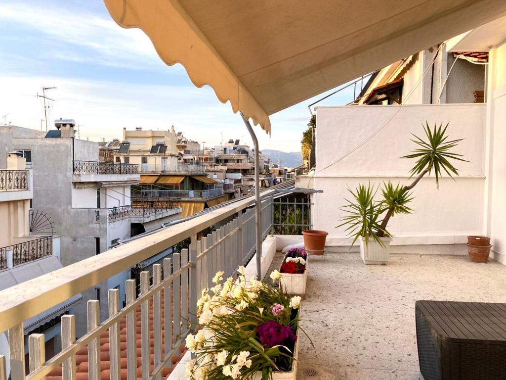 a balcony with flowers and plants on a building at Charming flat with an amazing view in Athens