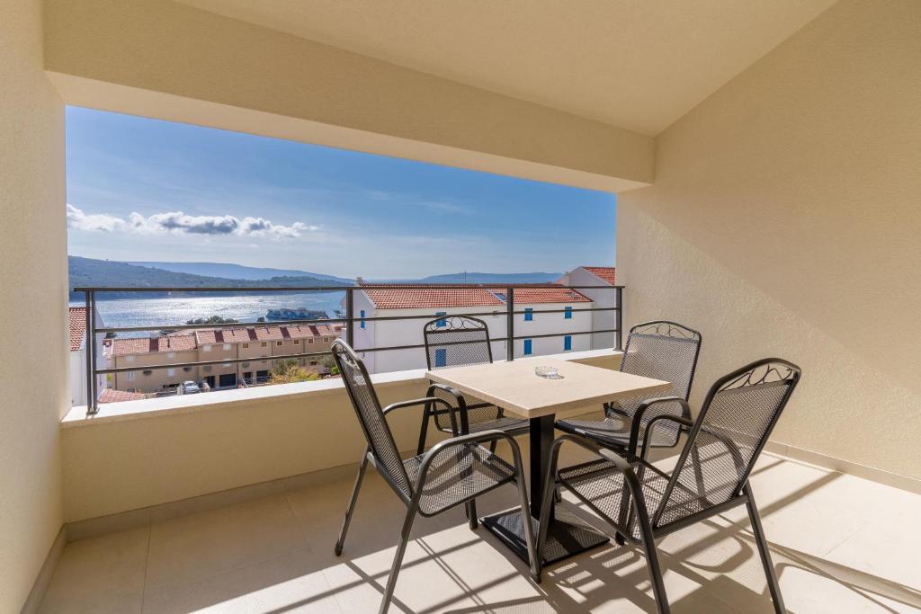 a balcony with a table and chairs and a view of the ocean at Breakaway Apartment in Cres