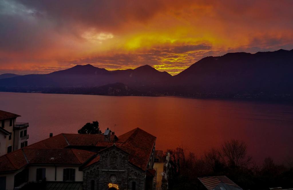 einen Sonnenuntergang über einem See mit Bergen im Hintergrund in der Unterkunft Antiche Cure di Ghiffa in Ghiffa