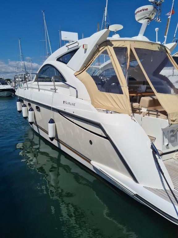 a white boat docked at a dock in the water at Marli II in Lymington