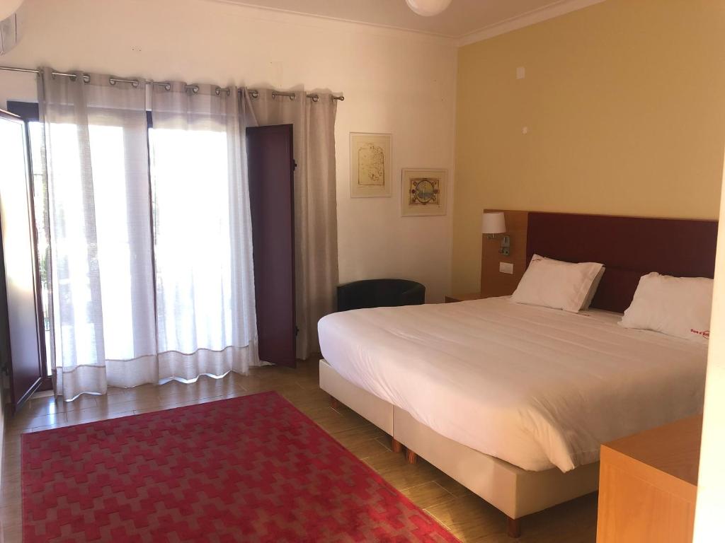 1 dormitorio con cama y ventana grande en Casa d´Edite, en Chamusca
