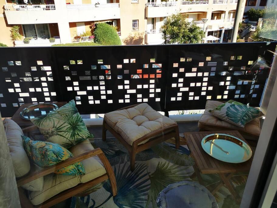 a balcony with couches and a table and a table at appartement carqueiranne le port in Carqueiranne