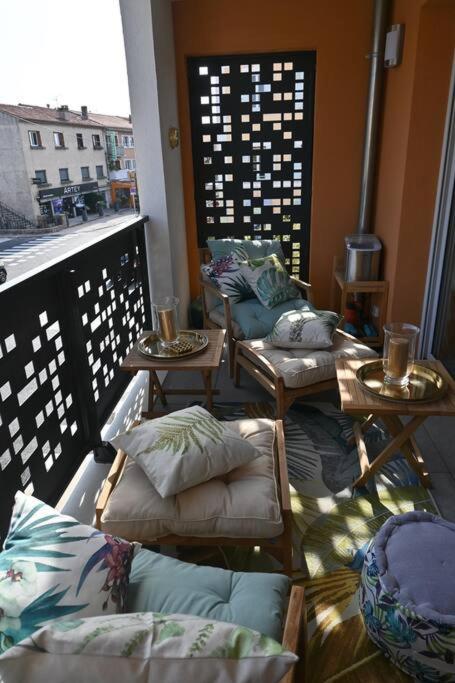 a balcony with two tables and two chairs with pillows at appartement carqueiranne le port in Carqueiranne