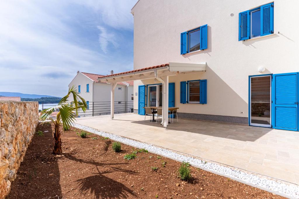 Casa blanca con ventanas azules y patio en Blue Sorbeto, en Cres