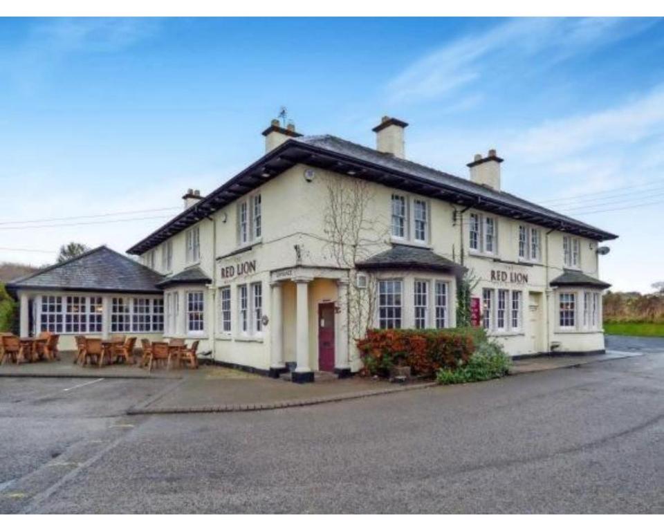 un gran edificio blanco con mesas delante en The Red Lion Hotel, en Chester-le-Street