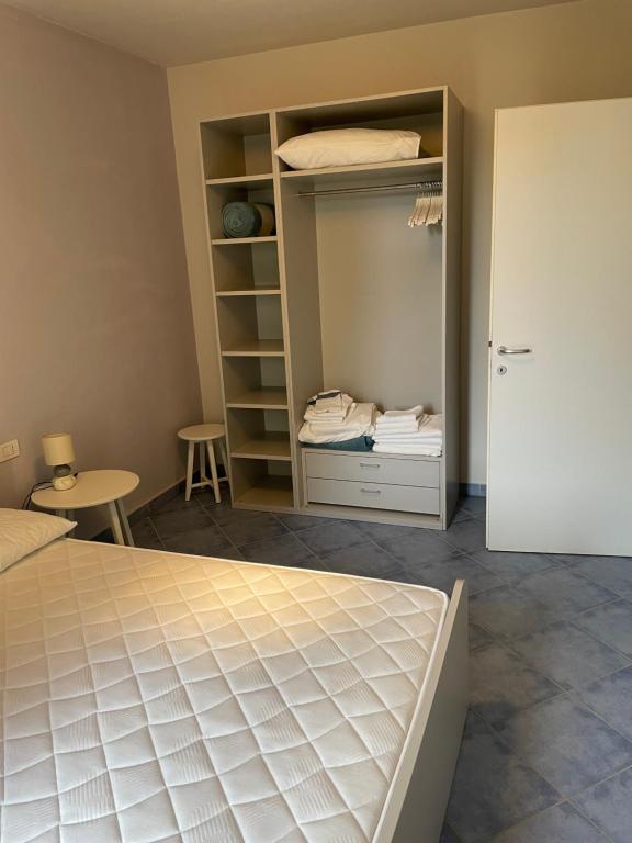- une chambre avec un lit et un placard ouvert dans l'établissement Borgo dei Mirti, à Santa Teresa Gallura