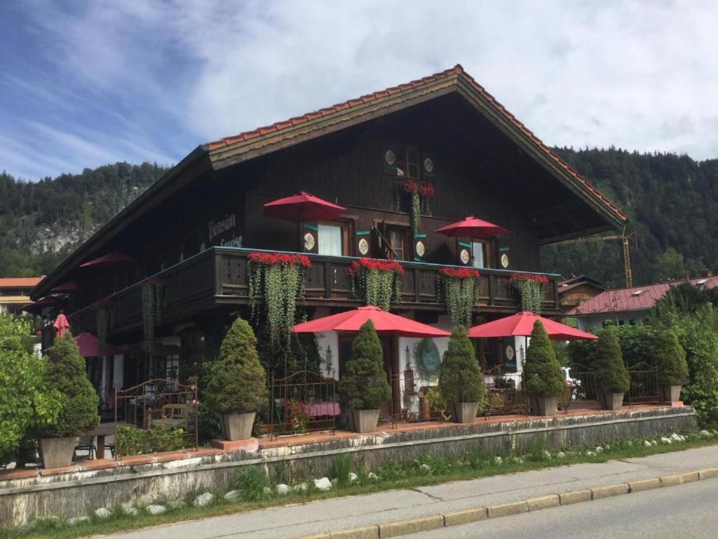 a building with red umbrellas in front of it at Haus Louise in Reit im Winkl